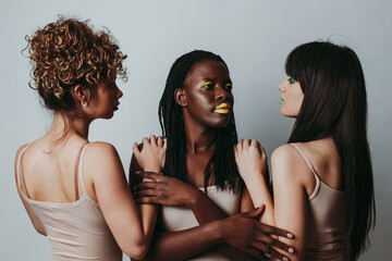 Wall Mural - Three girls from different ethnicities posing in studio for a 