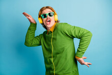 Photo Of Young Handsome Funky Funny Playful Man In Headphones Fooling Around Isolated On Blue Color Background
