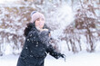 © soleg - woman playing with snow in winter outdoor and having fun on snowy winter