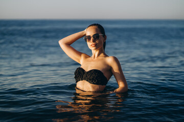 Wall Mural - Pretty brunette woman relaxing on the beach at the sea.