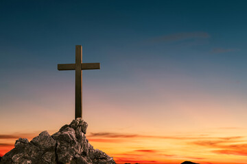 Wall Mural - cross crucifixion on a mountain cliff rock With a sunset background