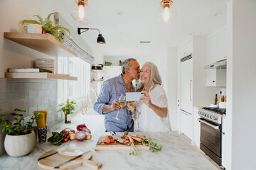 Elderly couple taking a selfie while cooking in a kitchen