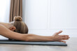 Young woman practicing restorative asana pose in yoga studio, closeup