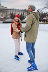 Canvas Print - Happy couple skating at outdoor ice rink