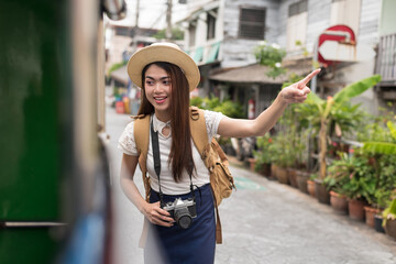 asian female traveller asking directions from taxi driver to get him to landmark in bangkok thailand