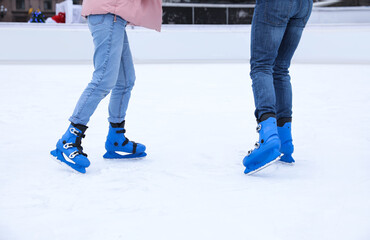 Canvas Print - Couple skating along ice rink outdoors, closeup