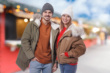 Wall Mural - Happy couple at Christmas fair. Bokeh effect