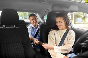 transportation, vehicle and payment concept - female car driver taking credit card from male passenger