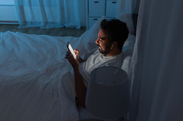 technology, internet, communication and people concept - happy smiling young indian man with smartph