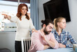 © JackF - Portrait of sad mature woman trying to talk with adult children in home interior