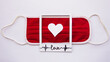 medical red mask with white heart in the middle of picture frame with word love as a pulse heart beat design on white background