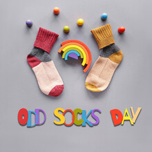 Odd Socks Day Text And Symbols. Mismatched Socks, Wooden Rainbow And Toy Figures. Social Initiative Against Bullying In School Or Workplace. Design For Anti-bullying Campaign Poster Or Cards.