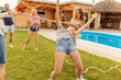 © Impact Photography - Friends having fun doing limbo dance at summer party by the pool
