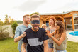 © Impact Photography - Friends having fun playing blind man's buff while at poolside summertime outdoor party