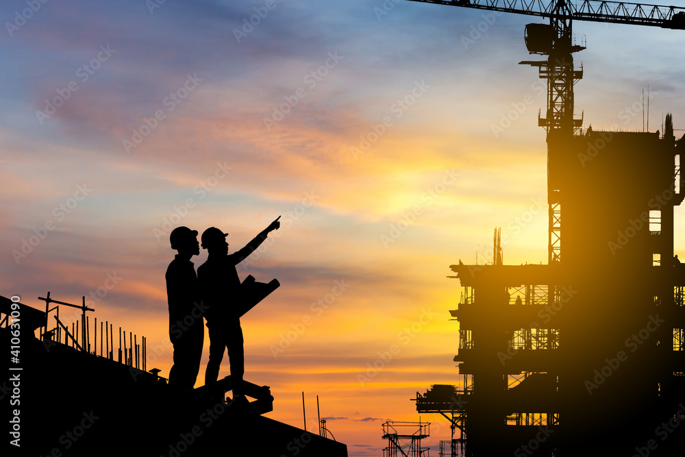 Silhouette of Engineer and worker checking project at building site background, construction site at sunset in evening time - obrazy, fototapety, plakaty 