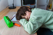 © Anna - Young boy of ten years old doing his homework sitting at the table at home. Tired child asleep when doinbg school excercises face on the desk.