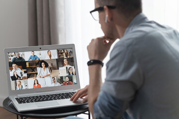 Wall Mural - View from back above shoulder on the laptop with diverse employees, coworkers on the screen, video call, online meeting. App for video conference with many people together