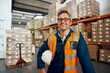 © StratfordProductions - Portrait of a happy male employee at manufacturing industry with stacked of cardboard boxes