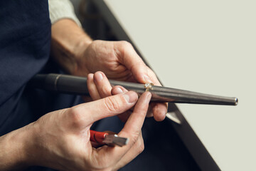 Wall Mural - Rounding. Close up hands of jeweller, goldsmiths making of golden ring with gemstone using professional tools. Craft production, precious and luxury jewel, hand made occupation. Workshop, artwork.