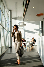 African American Business Woman Using Mobile Phone And Walking In The Office