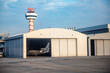 Aircrafts parking inside the hangar in airport and flight control tower behind