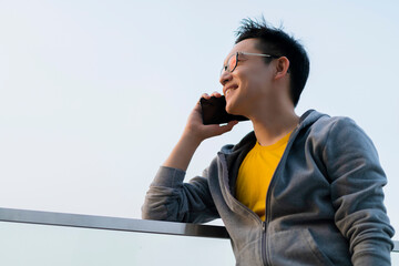 Poster - attractive smart asian freelance male casual cloth smileing cheerful confident conversation with smartphone communication outside building technology ideas concept