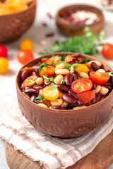 Sticker - Salad of white and red beans, tomatoes and herbs in a ceramic bowl close-up. Tasty vegan food