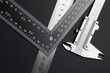 © Oleg - measuring tool, ruler square and caliper. lie on a dark background. close-up.