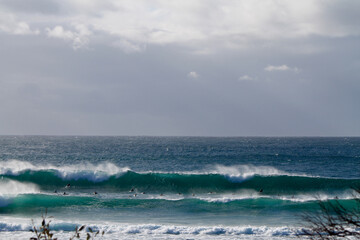 Canvas Print - Surfers facing a huge wave