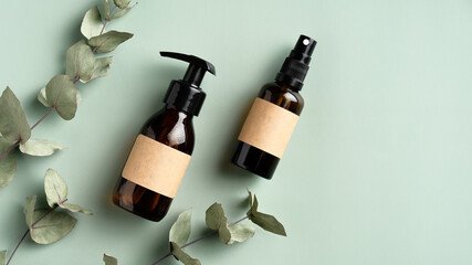 Wall Mural - organic natural cosmetic products with eucalyptus leaves on green background. amber glass spray bott