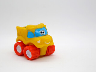 Plastic toy truck for children with human faces. Train with a friendly look and smile. Yellow truck for babies and toddlers.