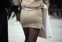 Closeup Of Girl Walking In The Street With A Beige Mini Skirt