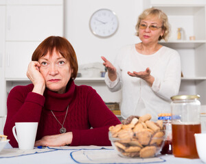 Wall Mural - Two upset mature ladies finding out relationship at home