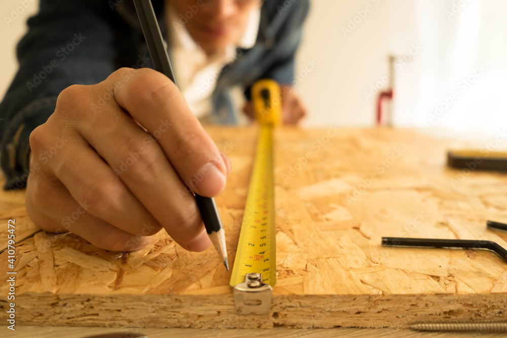 Close-up Of Carpenter Measuring Wood In Carpentry Workshop - obrazy, fototapety, plakaty 