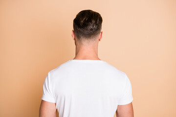 Wall Mural - Rear back behind view portrait of nice attractive guy wearing modern haircut isolated over beige pastel color background