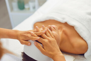 Wall Mural - Woman getting professional face lifting massage while relaxing in modern spa salon