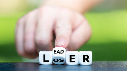 Wall Mural - From a loser to a leader concept. Hand turns dice and changes the word loser to leader.