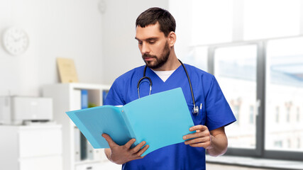 Sticker - healthcare, profession and medicine concept - doctor or male nurse in blue uniform reading medical report in folder over medical office at hospital on background