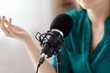© Syda Productions - technology, mass media and people concept - close up of woman with microphone and headphones talking and recording podcast at studio