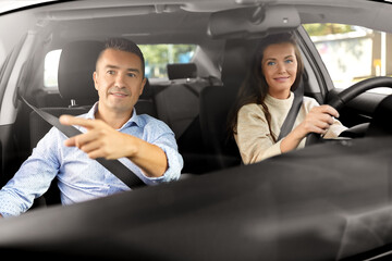 Poster - driver courses and people concept - car driving school instructor teaching young woman to drive