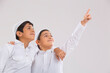 © IndiaPix - Young Muslim boys wearing cap looking away, smiling and pointing