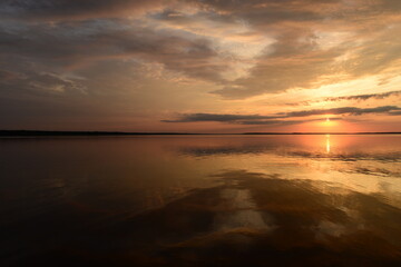 Wall Mural - Twilight sky in colorful bright sunlight reflects off on the water surface