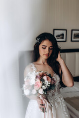 A bride in a white dress is holding a beautiful wedding bouquet.