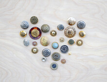 A Heart Made Of Vintage Metal Buttons On A Wood Background
