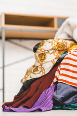 Wall Mural - Pile of unfolded clothes for laundry on the floor. Heap of used clothes for donation and recycling. Concept of minimalism, mess and wardrobe cleaning