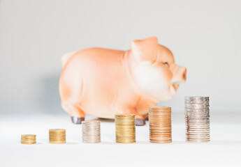 Saving by putting coins into the piggy bank.