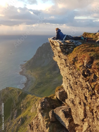 Woman Lying On Rock By Mountain Against Sky