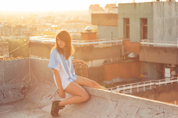 Sticker - Female football fan sitting on a building rooftop terrace at sunset