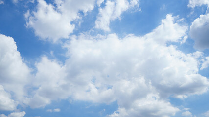 summer sky is bright blue. there are clouds floating through. feel relax when looking. see the sun o