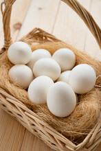 White Eggs In The Basket Scattered On Wooden Table. The Farm's Products.